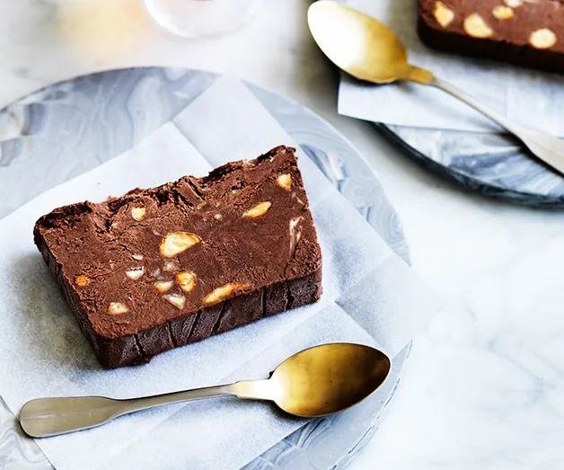 Chocolate and almond slice on a plate with a golden spoon.