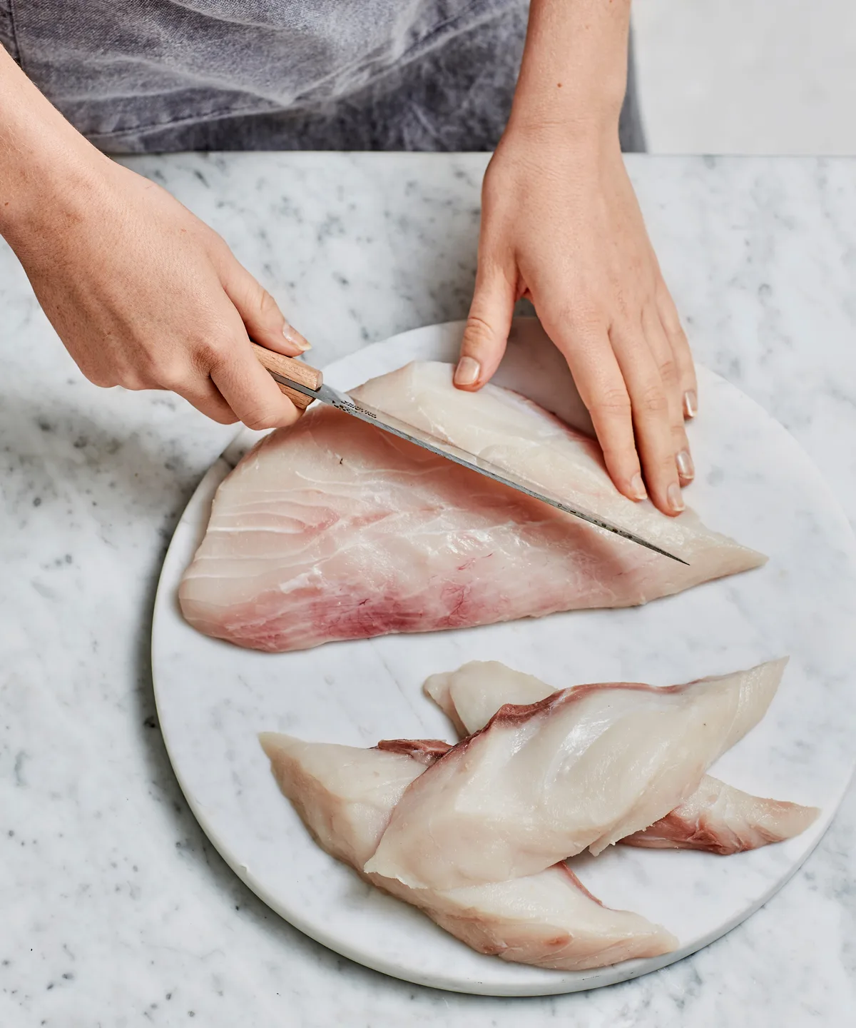 Slicing the fish into pieces to prepare for flour and batter