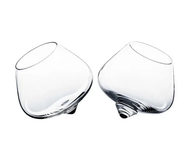 Two clear, tilted cognac glasses on a white background.