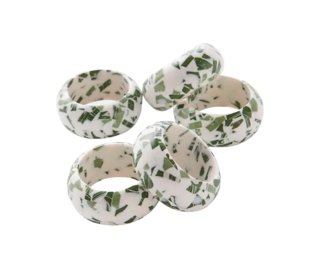Chunky resin rings with white and green pattern, stacked in a pile.