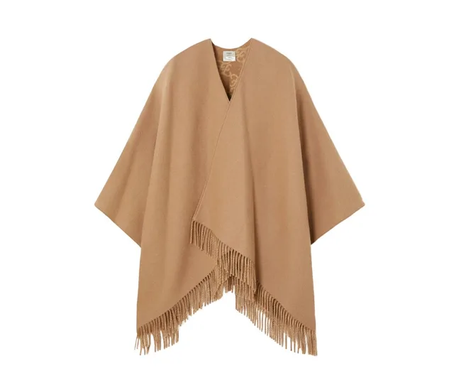 Brown wool poncho with fringe detailing at the bottom edges, displayed against a white background.