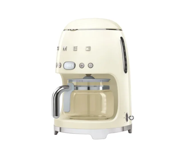 Cream-colored Smeg coffee maker with glass carafe and stainless steel accents.
