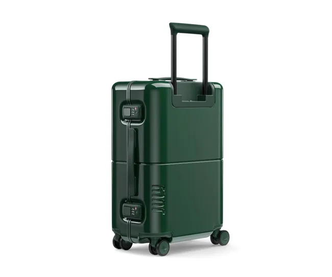 Green hardshell suitcase with wheels, retractable handle, and combination locks, viewed from a slight angle.