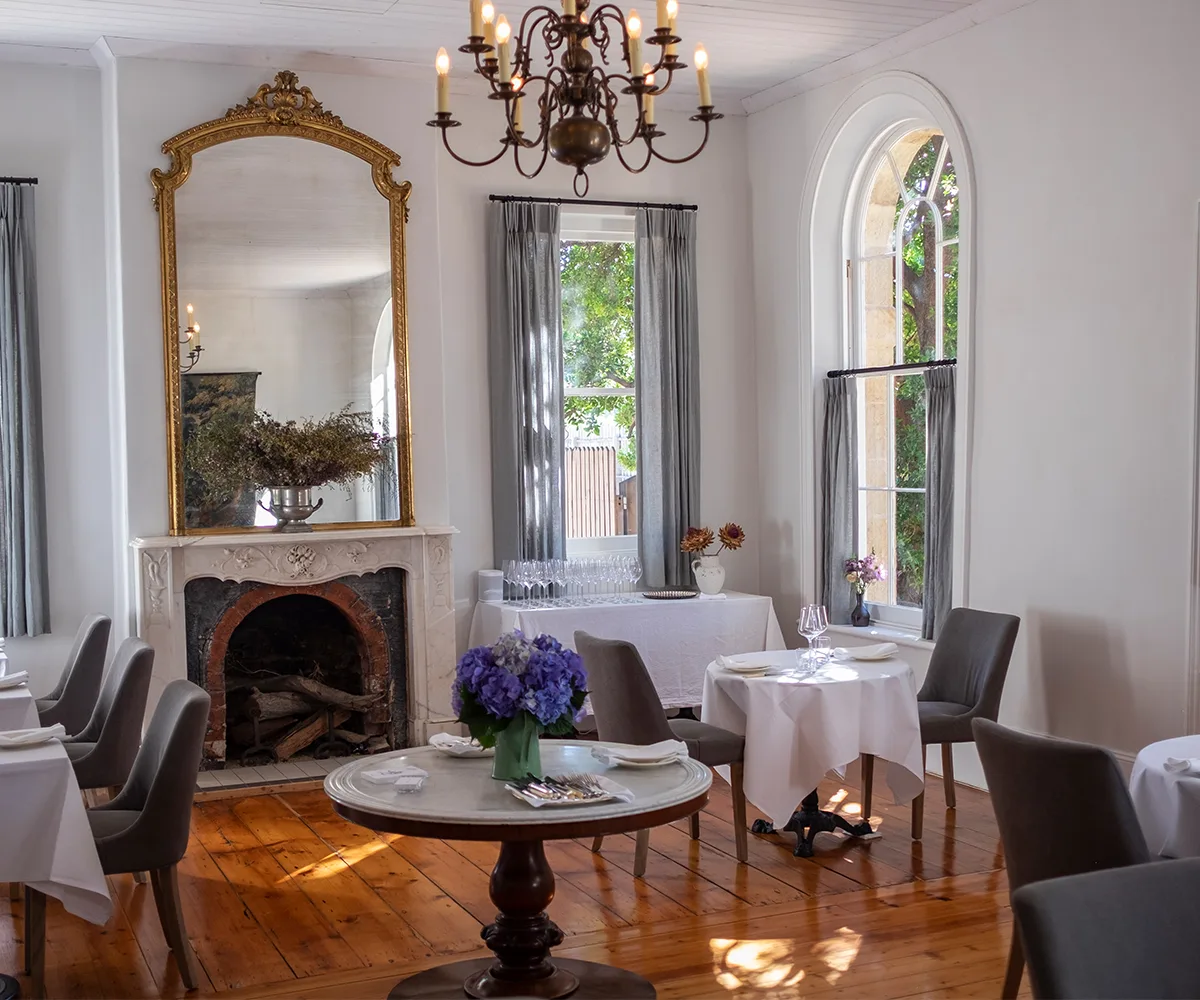 Chauncy in Heathcote, Victoria dining room with hardwood polished floors, white tablecloths and vintage chandelier