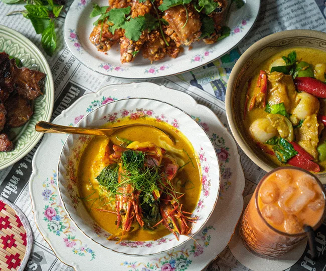 Porkfat in Haymarket, Sydney. An aerial view of several Thai dishes: the spicy crisp chicken wings, the crab curry and the Mooloolaba prawns curry.