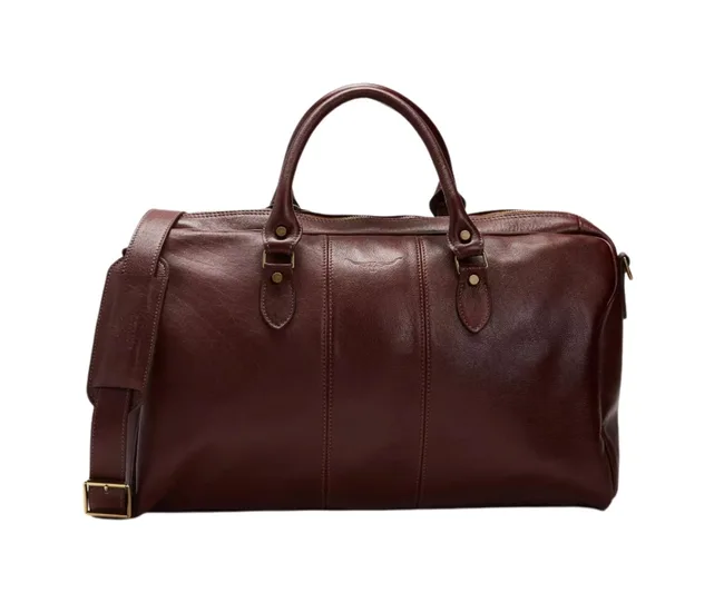 Brown leather duffel bag with handles and a detachable shoulder strap, featuring brass hardware.