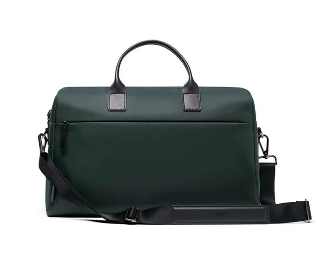 Dark green duffle bag with black handles and adjustable strap.
