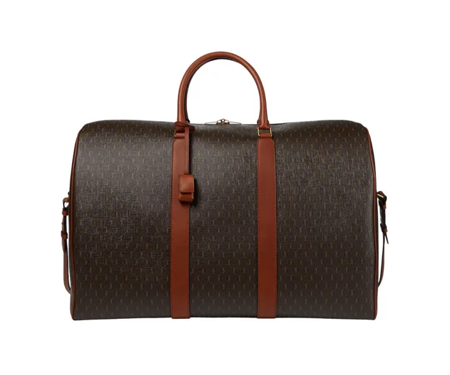 Brown and dark patterned luxury duffel bag with leather straps and handle.