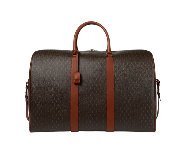 Brown and dark patterned luxury duffel bag with leather straps and handle.
