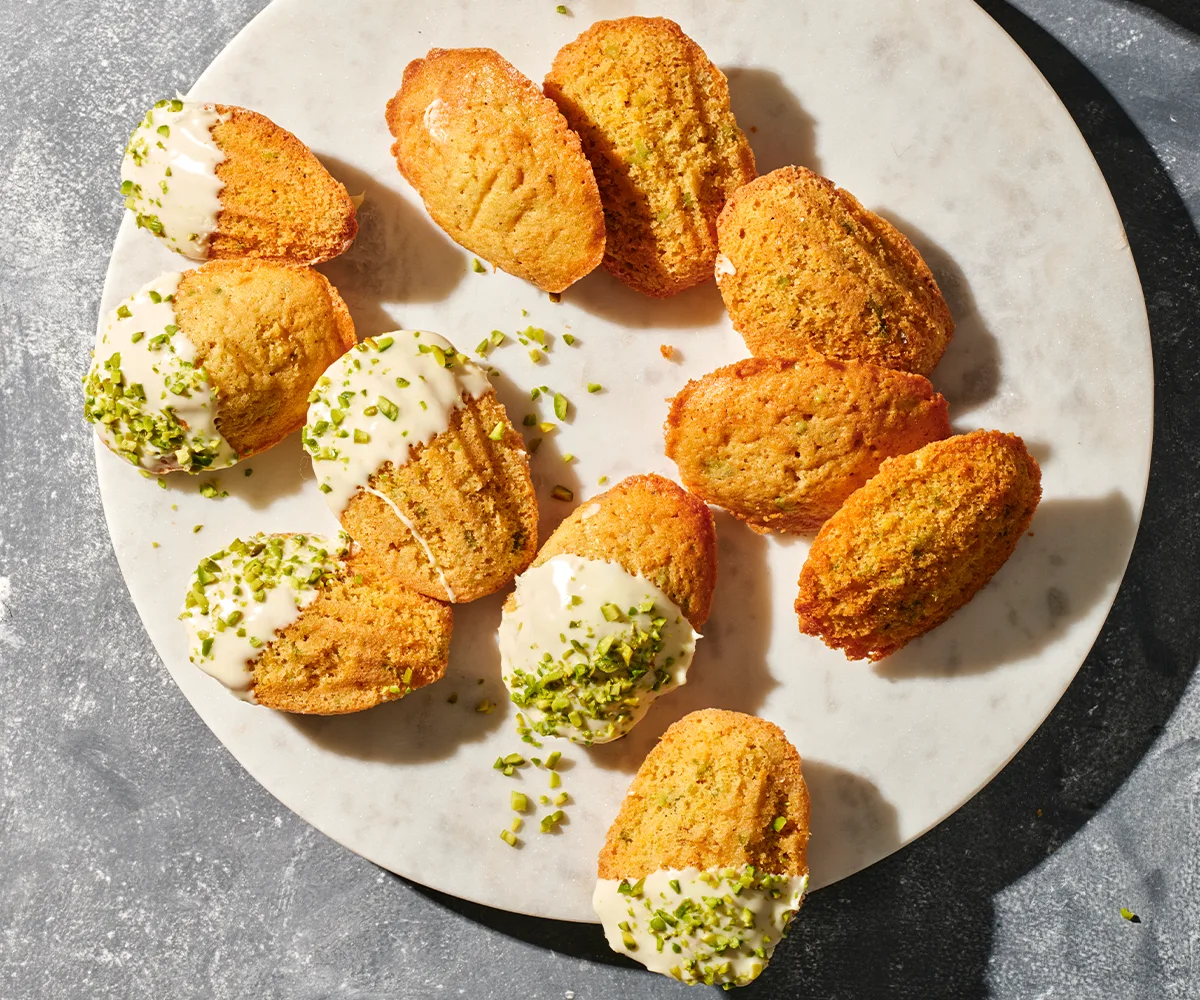 An aerial view of lemon myrtle brown butter madeleines on a circular white plate