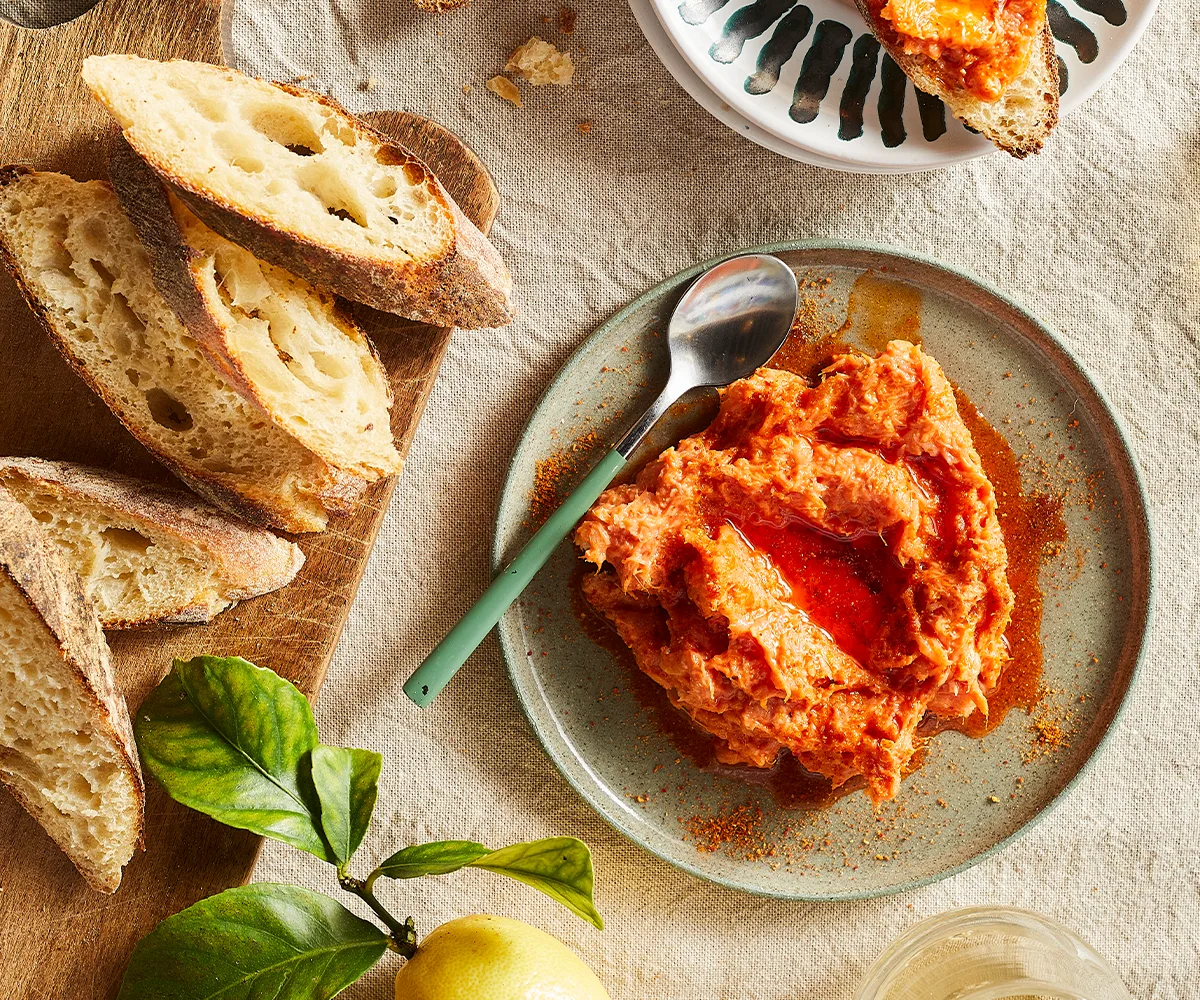 An aerial view of a small plate of Paski's pappalá with crusty sliced bread on the side.