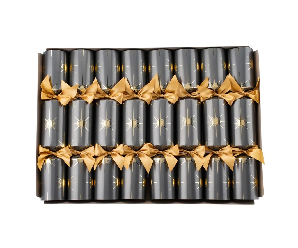 Box of Christmas crackers in dark paper with gold star and ribbon decoration, arranged neatly in rows.