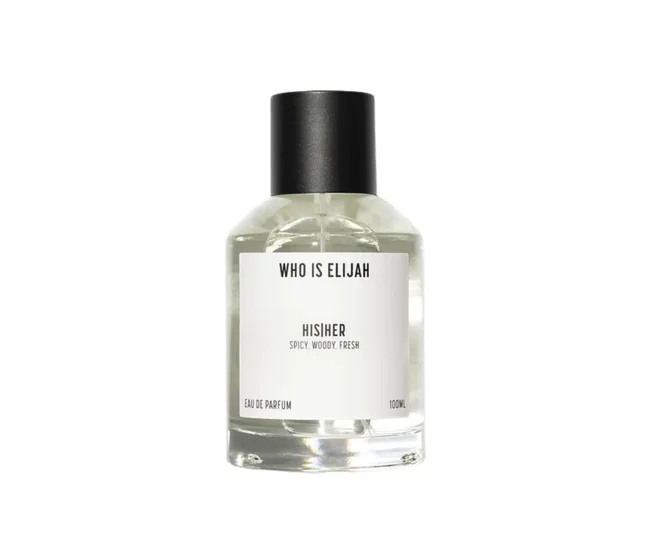 A bottle of "Who Is Elijah" eau de parfum labeled "HIS|HER," featuring spicy, woody, fresh notes, 100ml size.