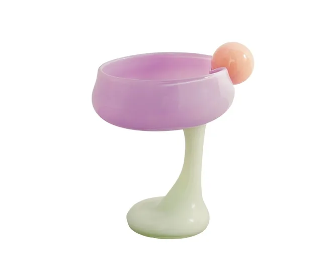 A pastel-colored glass with a lilac bowl, pale green stem, and peach sphere accent, set against a white background.