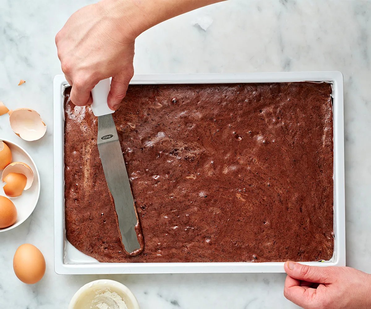 yule log batter being spread in a sheet tray