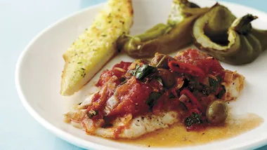 Baked fish with tomatoes, olives and garlic bread