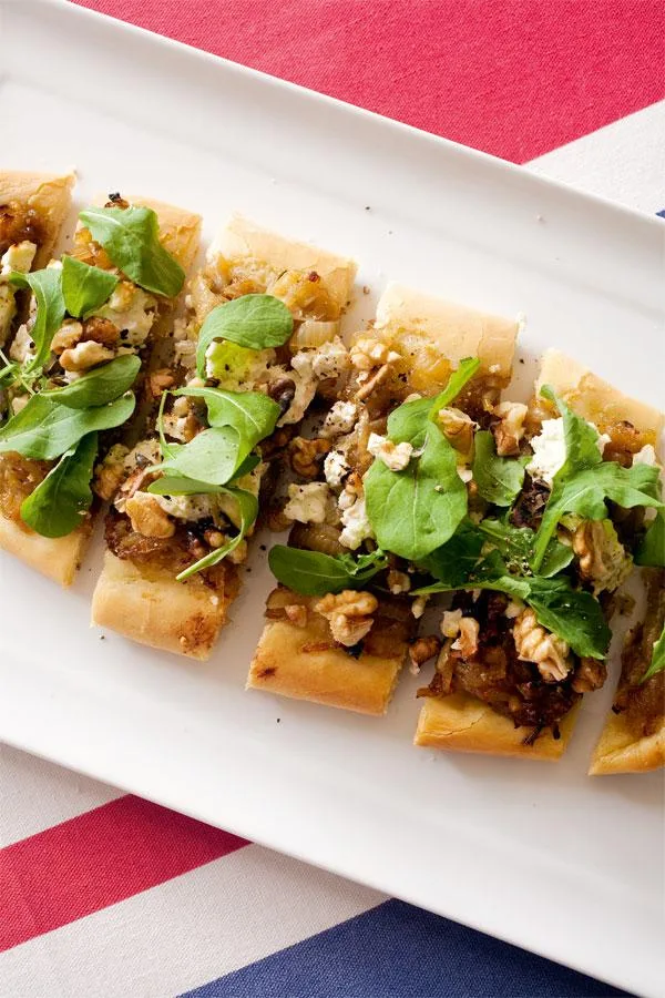 Pizza with caramelised onion, feta, rocket, and walnuts