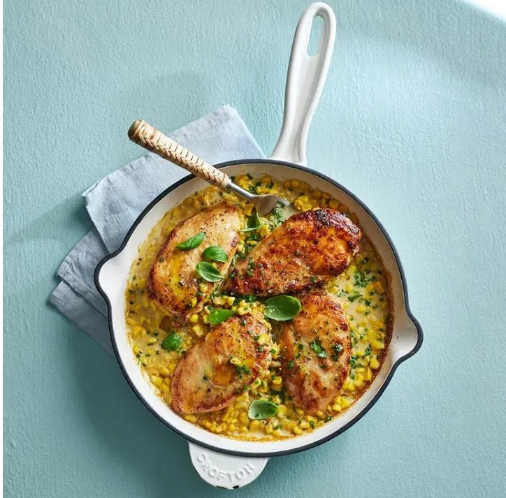 skillet with chicken fillets and corn in creamy sauce