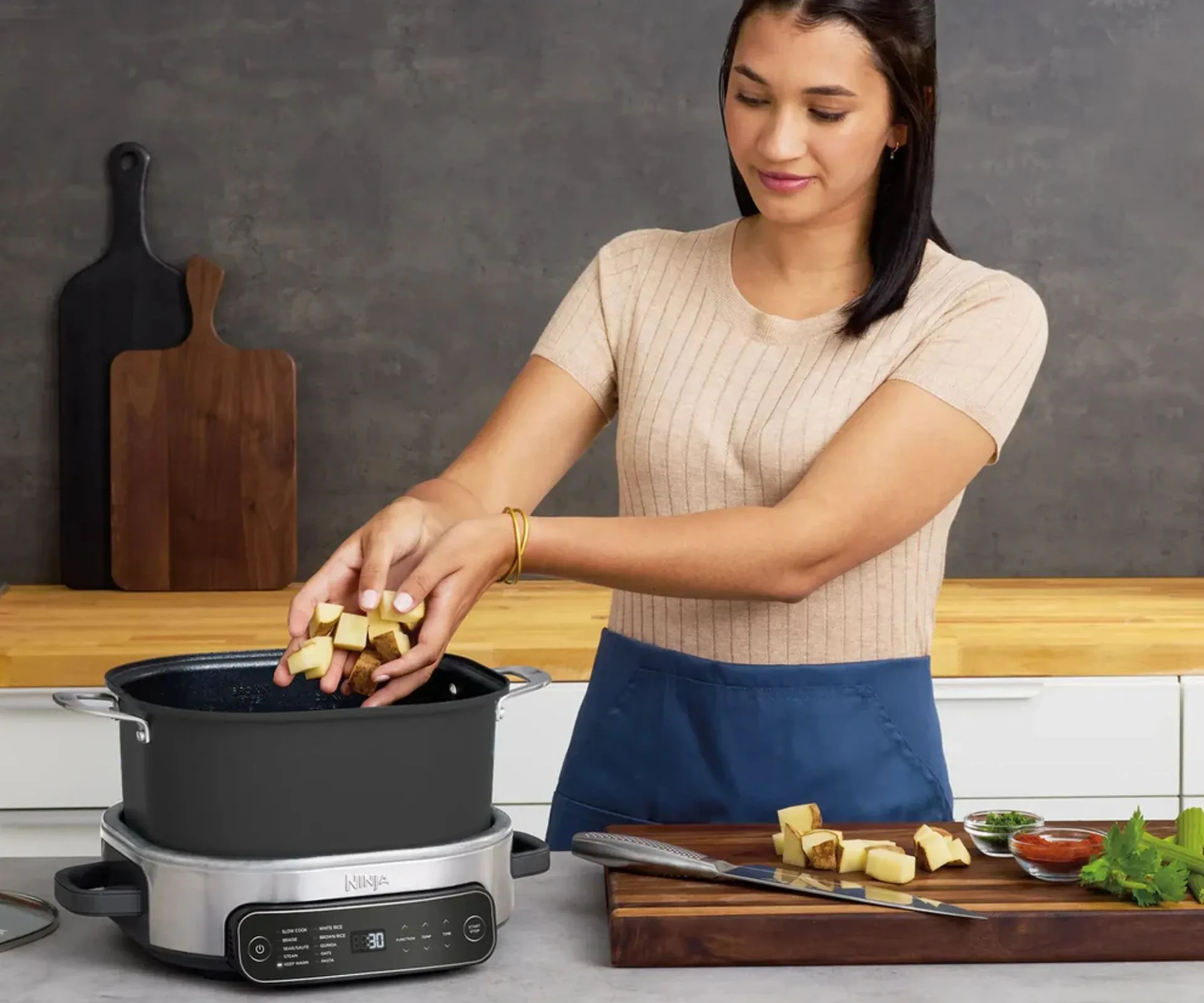 Woman putting potatoes in the Ninja slow cooker 