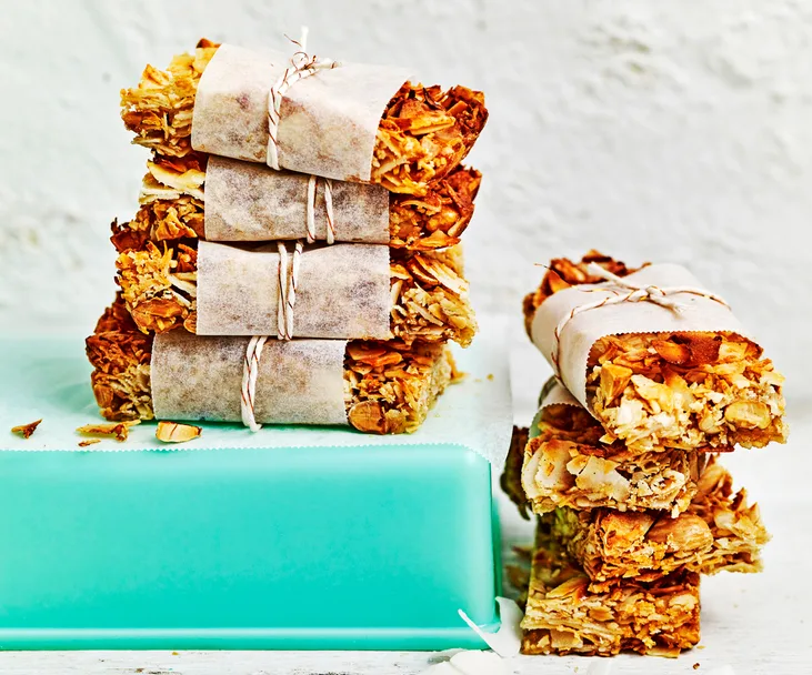 Coconut, almond and ginger bars stacked on top of each other wrapped with paper