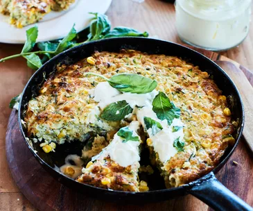 cheesey courgette corn bake topped with sour cream and herbs