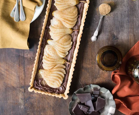 pear and chocolate tart on wooden table