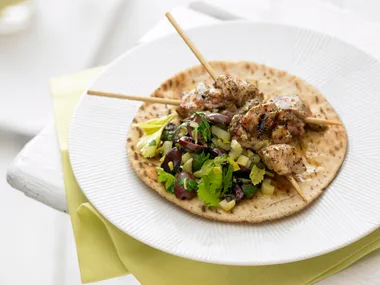 Chicken kebabs with celery and olive salad