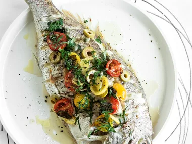 Whole roast snapper with olives, cherry tomatoes, lemon and oregano