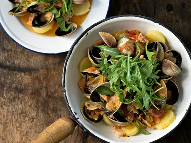Clams on steamed new potatoes and rocket