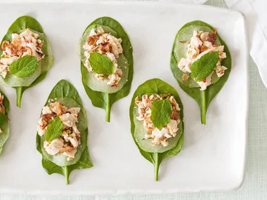 Shredded chilli and lime chicken, with crispy shallots on spinach leaves