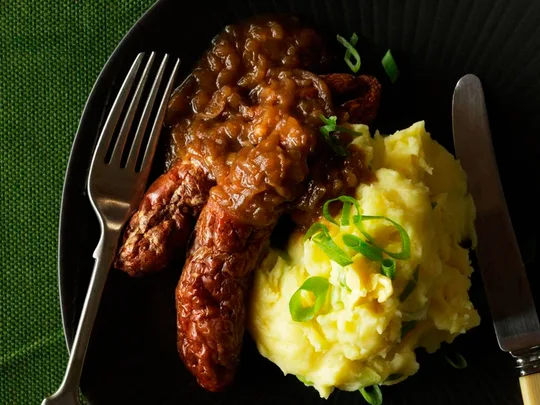 Champ with sausages and brown onion gravy