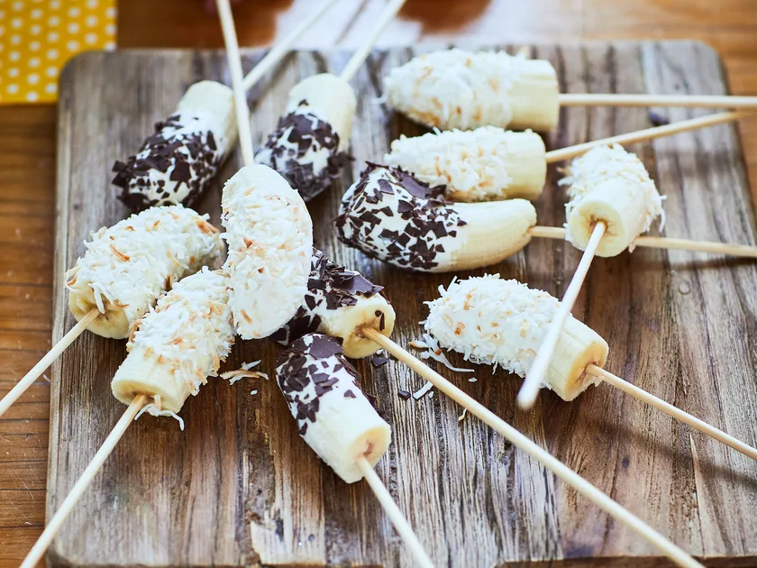 Frozen bananas dipped in yoghurt, coconut and chocolate