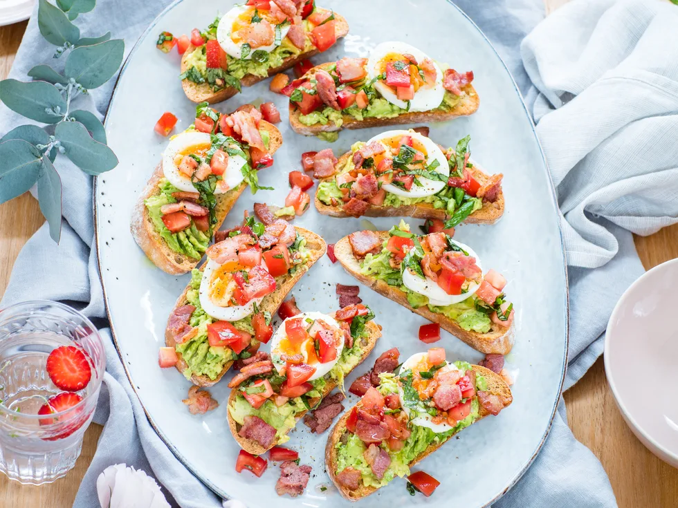 Brunch bruschetta with bacons, eggs and smashed avocado
