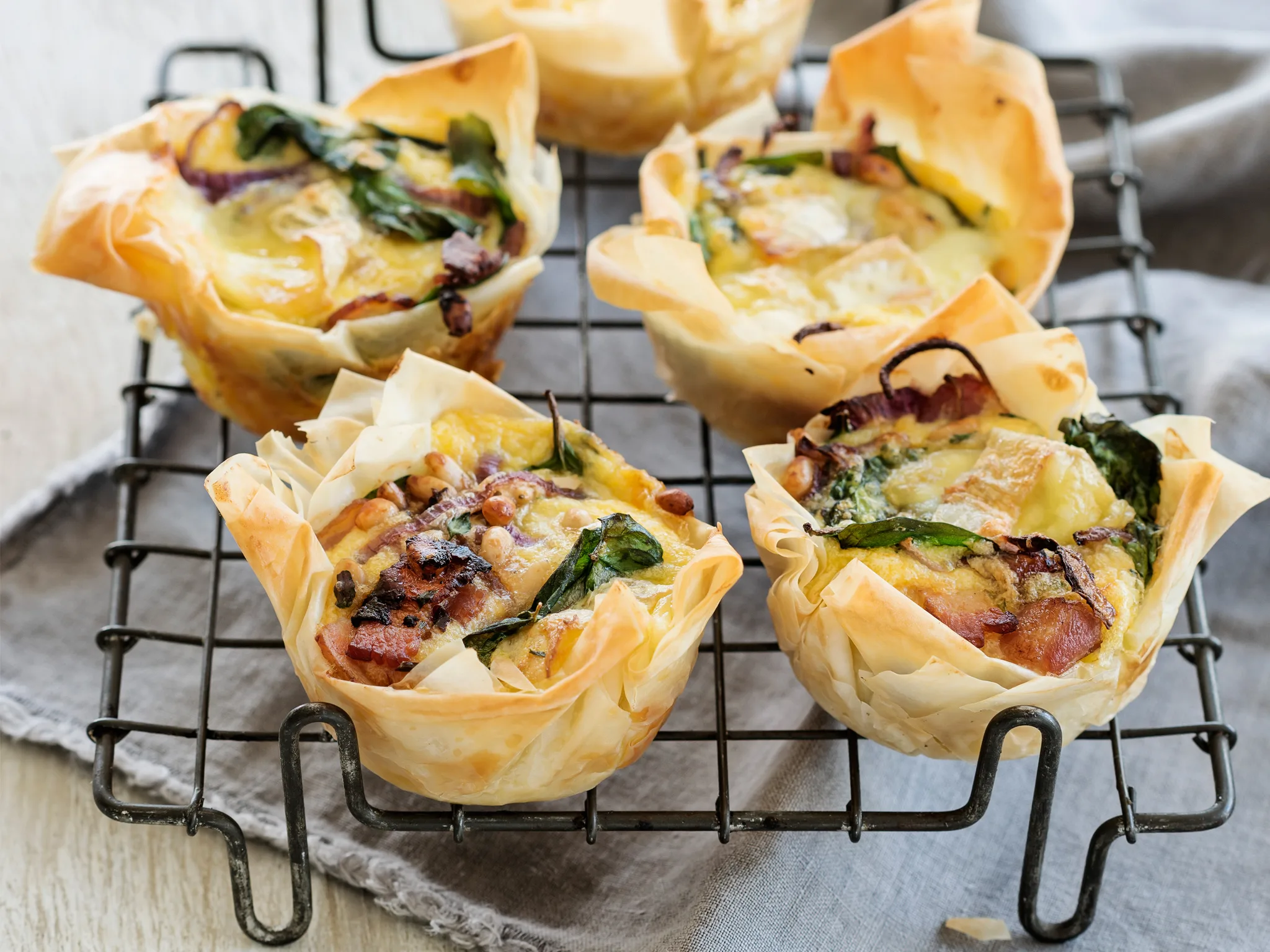 Brie and bacon filo tarts with spinach and pine nuts