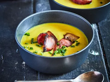 Curried pear and parsnip soup with crispy bacon and chives