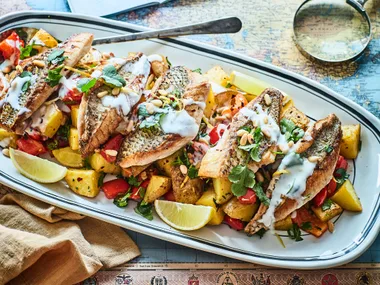 Lebanese batata harra (spiced potatoes) with pan-fried fish and tahini yoghurt sauce