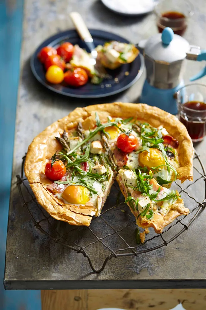 Portrait image of a breakfast tart featuring cherry tomatoes and rocket