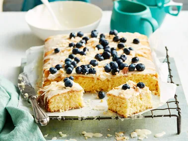 pineapple coconut cake with blueberries on top of running royal icing