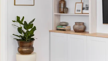 White room styled with a brass pot and an indoor plant