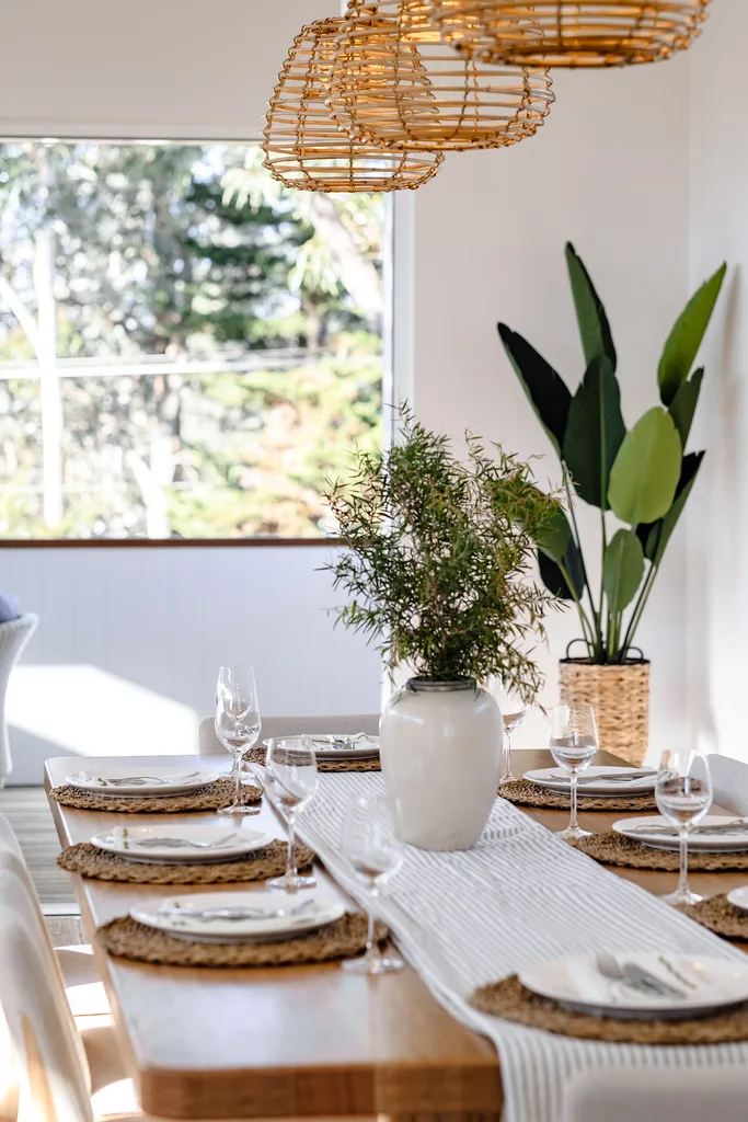 Coastal style dining room with bird of paradise plant in the background.