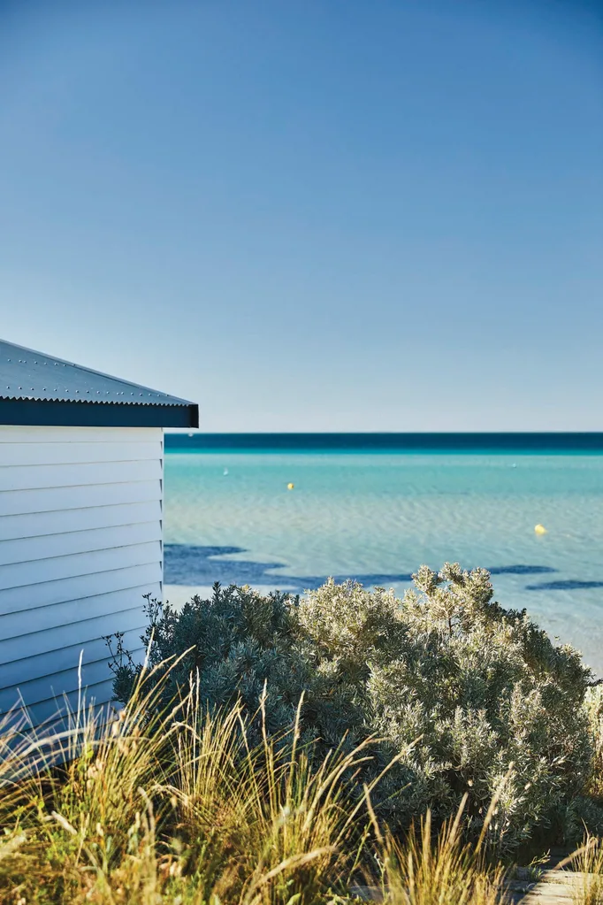 Corner of a white weatherboard house overlooking the ocean