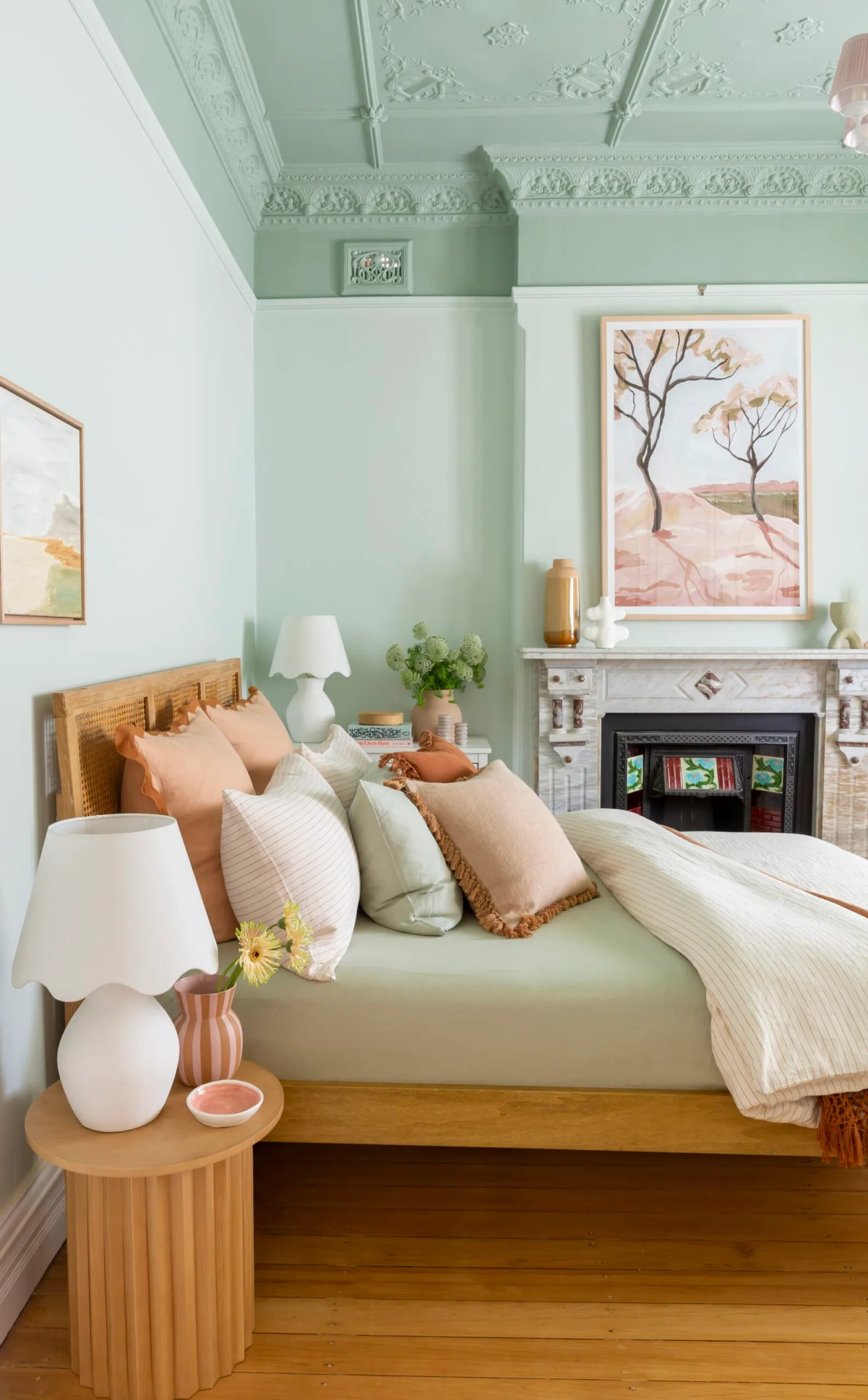 blue painted bedroom with sage green bed in the middle and neutral coloured cushions