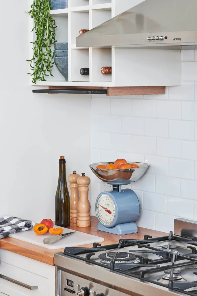 White and timber kitchen with a stainless steel range hood with mesh filters