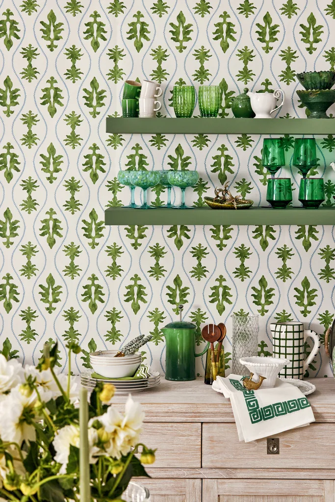 green wallpaper in kitchen with green glassware on wood shelves