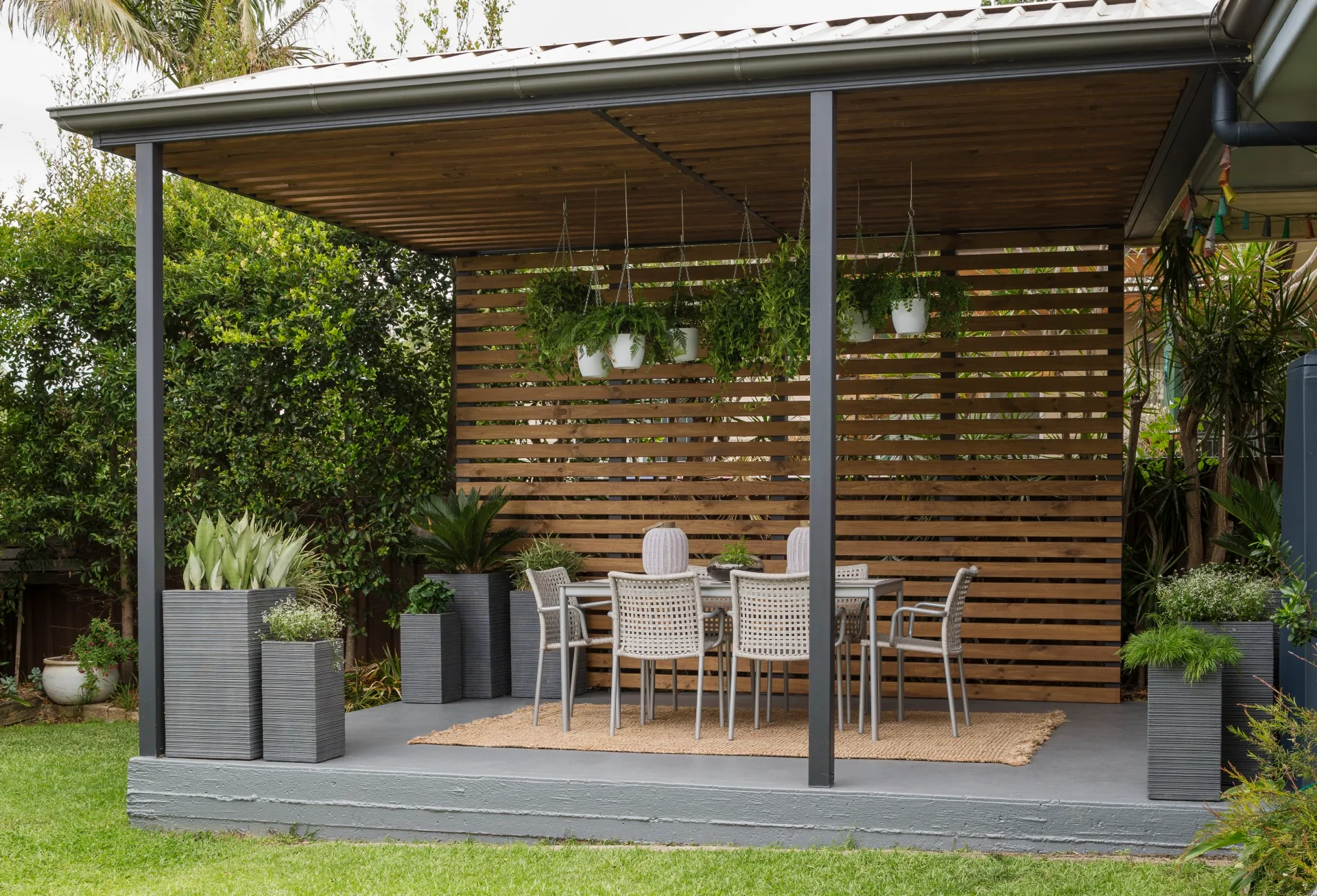 pergola made from wooden slats with patio underneath and tables and chairs