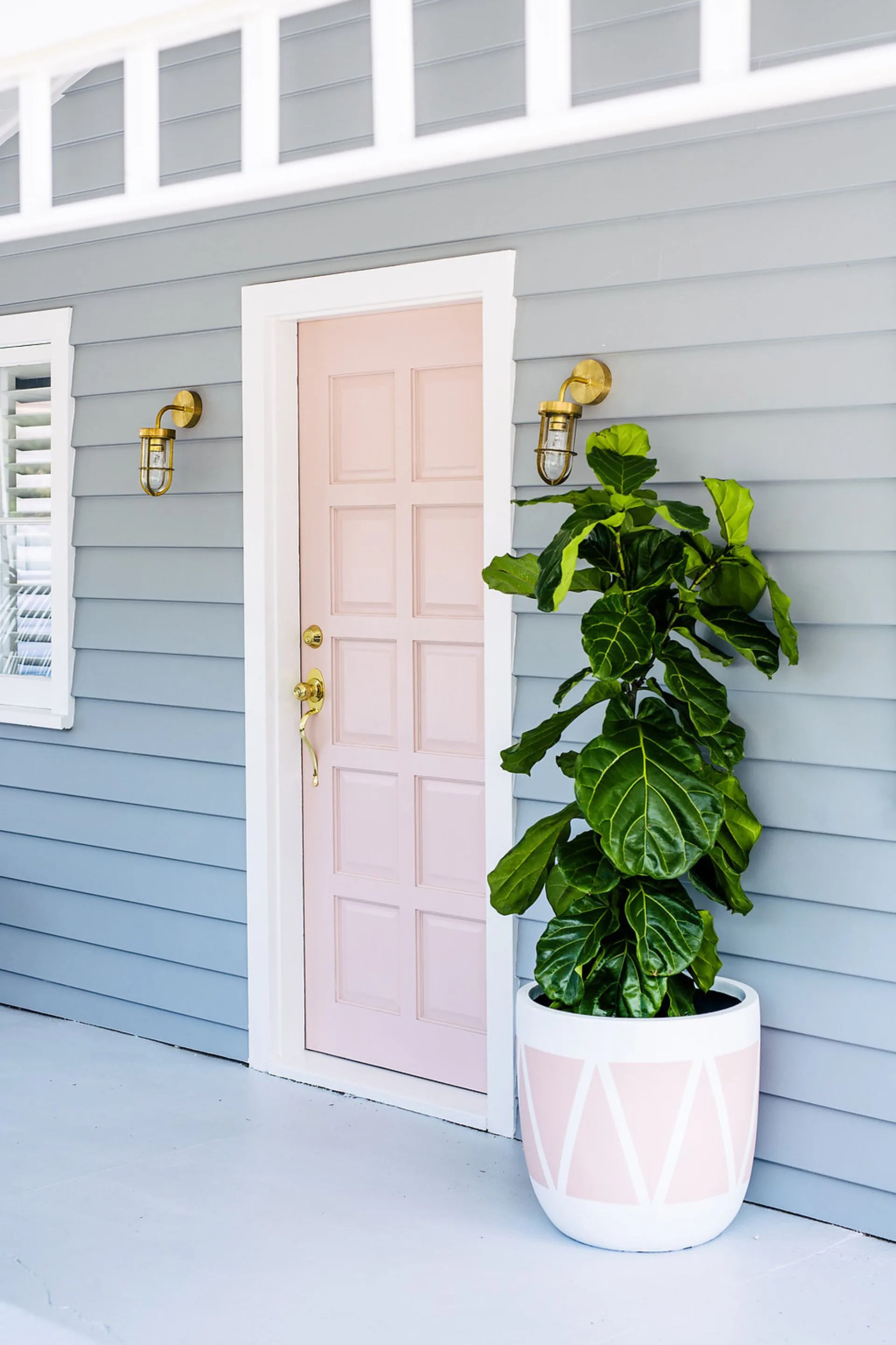 grey home exterior with pink pastel door