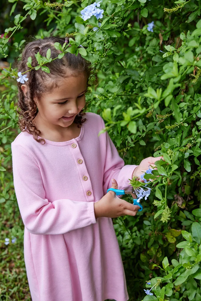 child searching for flowers in garden