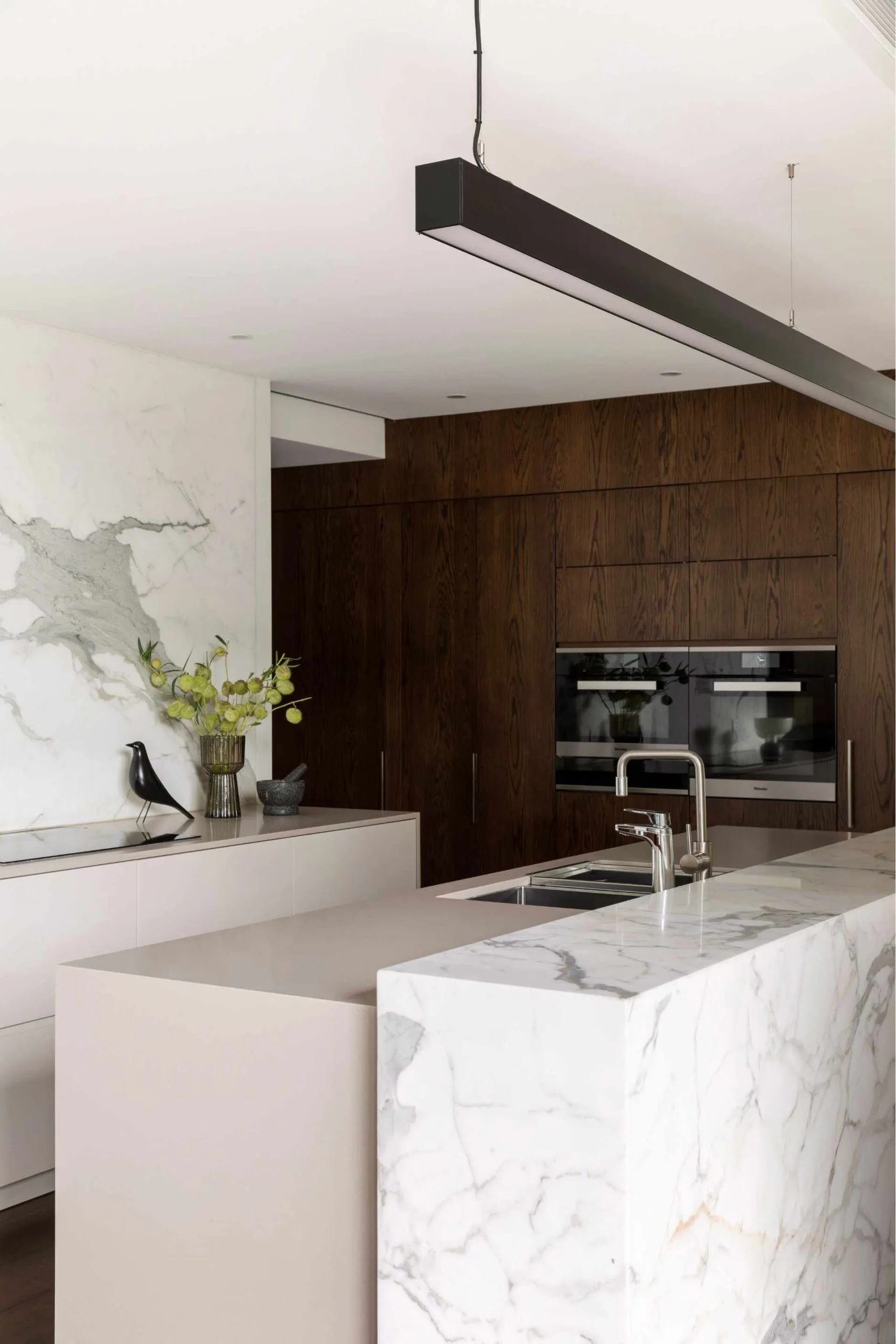 modern kitchen with marble island and walnut cabinetry 