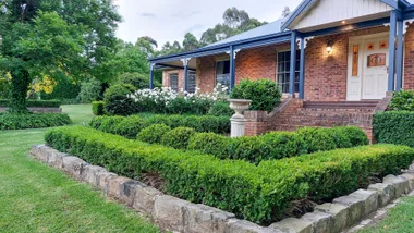 hero image for bath house garden with buxus hedges and old house