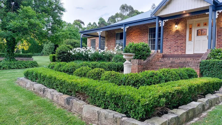 hero image for bath house garden with buxus hedges and old house
